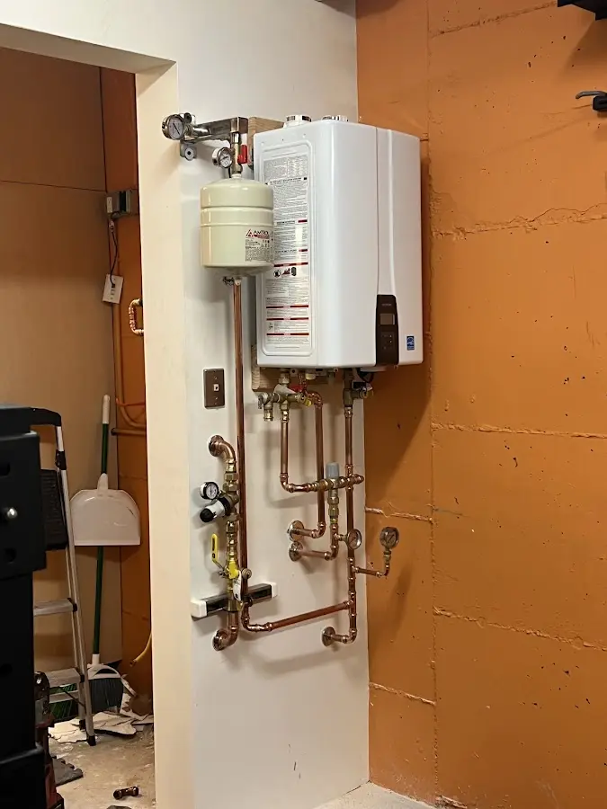 Plumbing technician inspecting water heater connections in Dearborn Heights